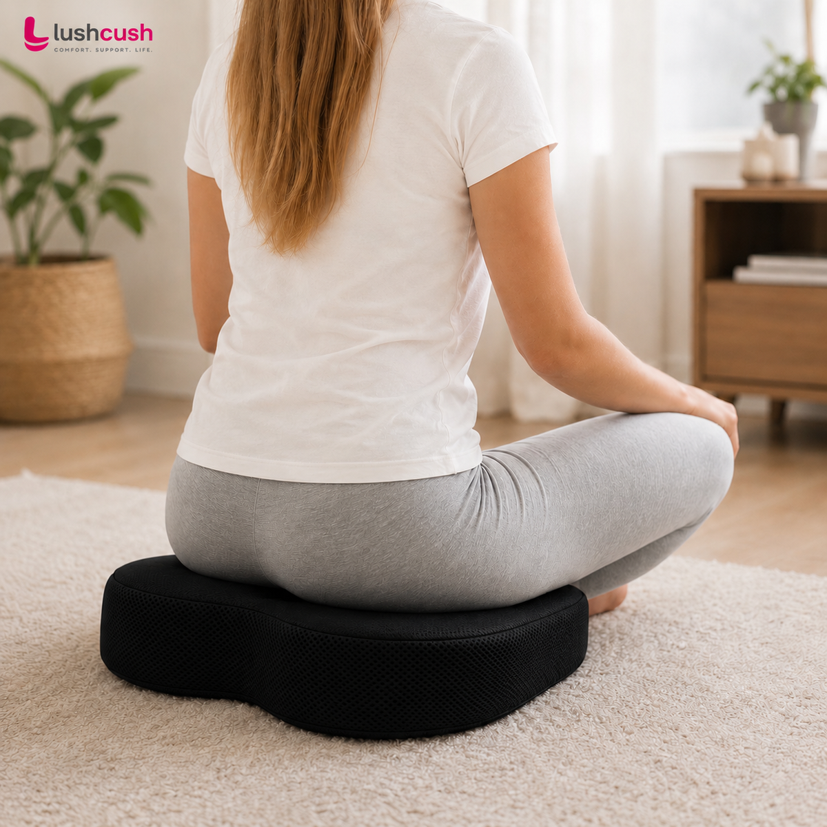 Woman sitting comfortably on LushCush ergonomic coccyx cushion for supportive seating at home